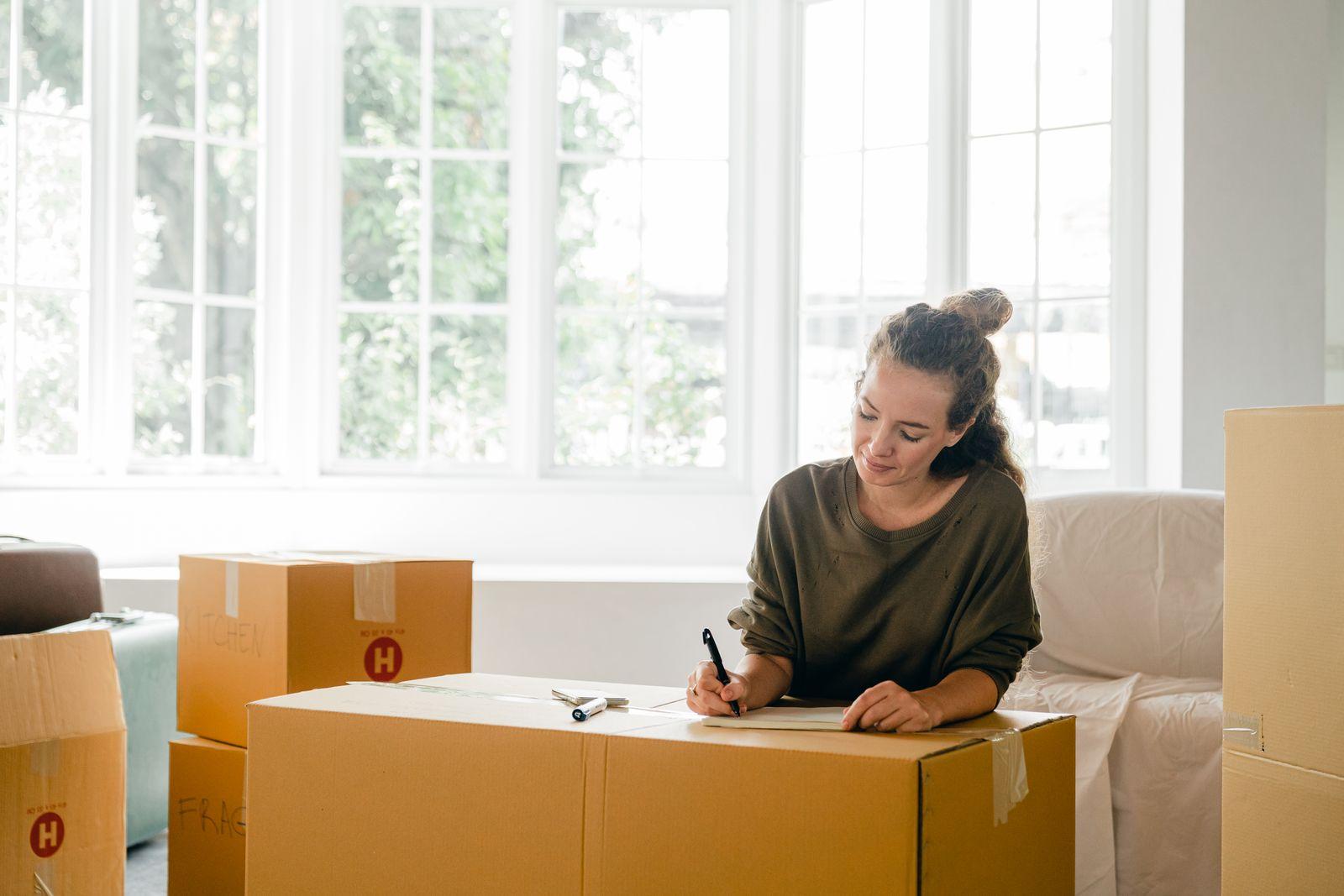 Personne qui étiquette des cartons dans un appartement lumineux