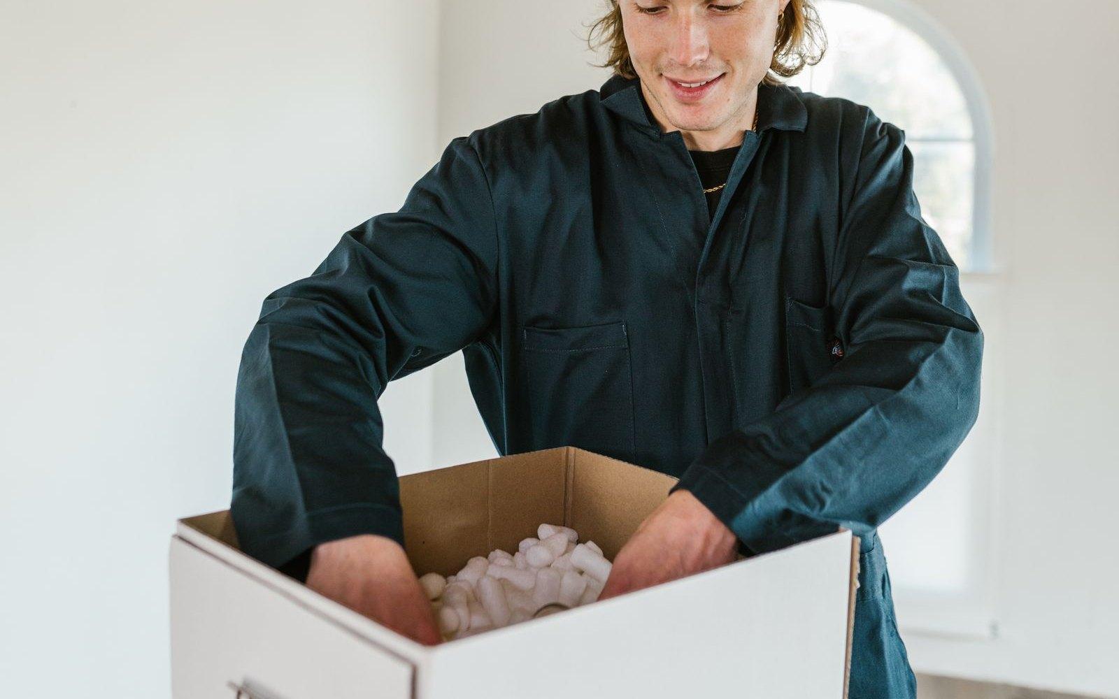 Personne qui protège des affaires dans un carton de déménagement